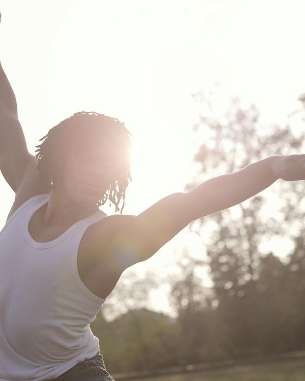 Man stretching outdoors feeling flexible and refreshed in the morning sun.